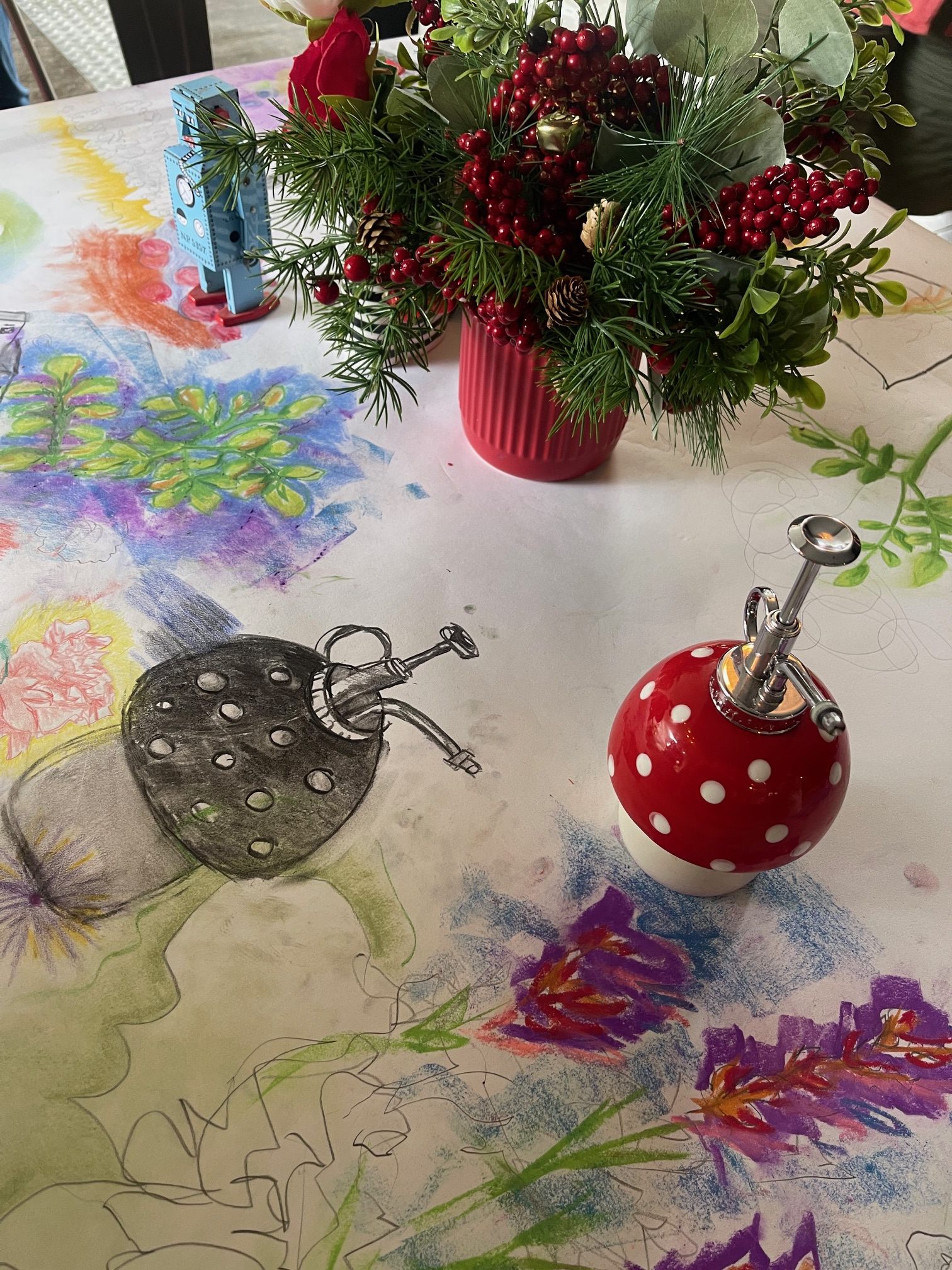 Close-up of a mushroom-shaped object and colourful workshop sketches spread across the table