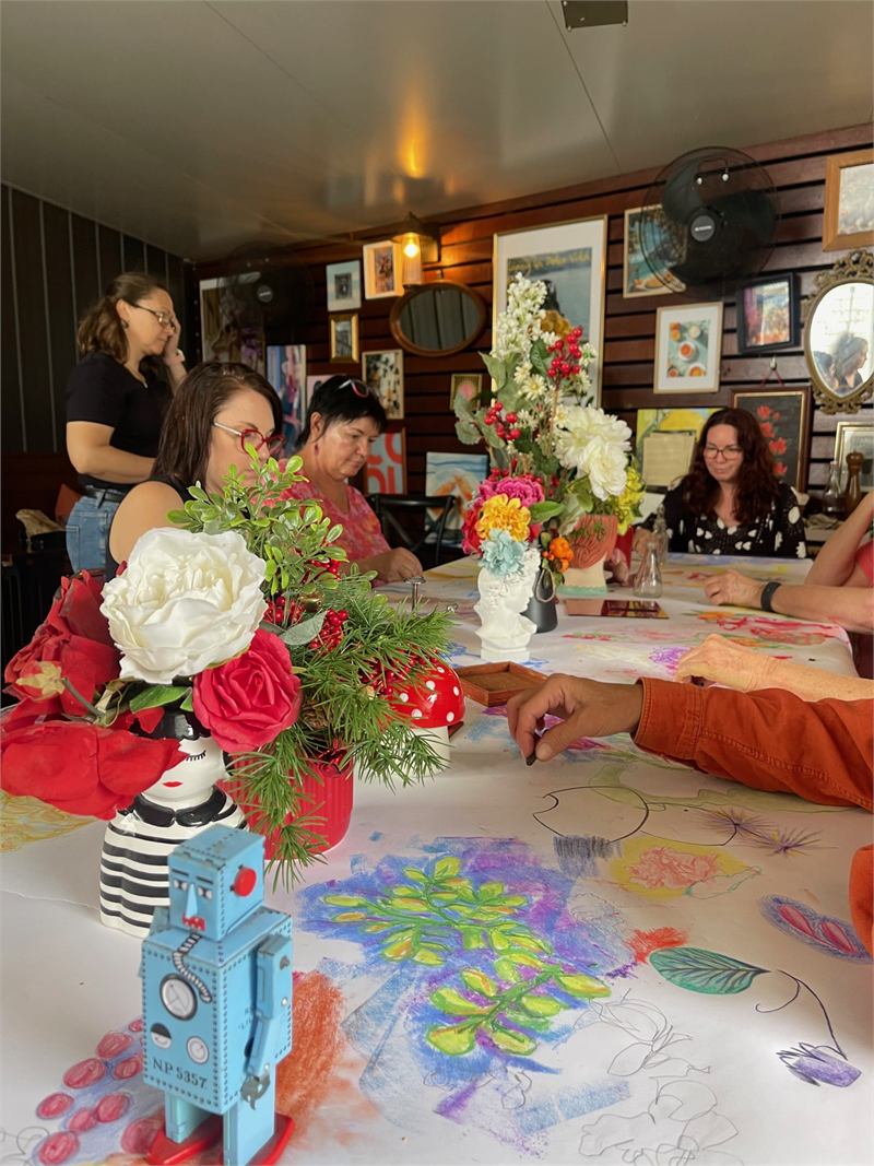People gathered around a drawing workshop table at Osteria Epoca